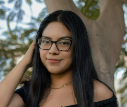 a girl with dark hair and glasses